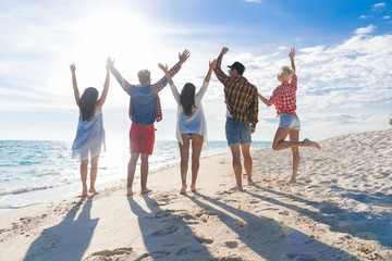 Wall Mural - young people group on beach summer vacation, raised hands friends back rear view seaside sea ocean h