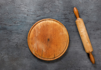 Aufkleber - Wooden board with rolling pin on the dark stone surface