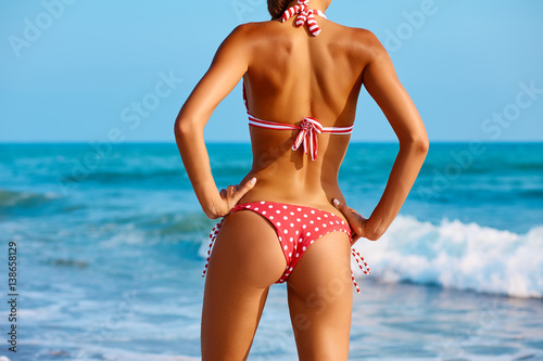 Zdjęcie XXL Seksowny plecy piękna kobieta w kreatywnie czerwonym bikini na dennym tle. Sportowe pośladki.