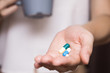 Woman hands with pills and Mug of water