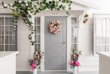 White Small Wooden House With Gray Door. Spring Flower Decoration