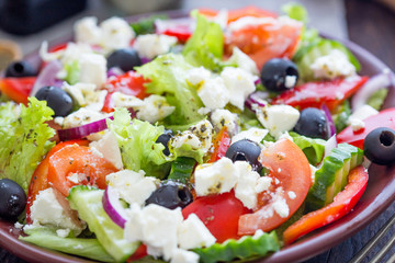 Wall Mural - Greek Salad with Fresh Vegetables, Feta Cheese and Black Olives, Close-up View