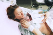 Mother holding her newborn baby after labor in a hospital.