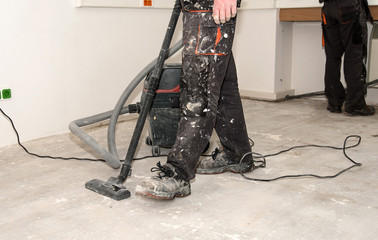 Worker use vacuum cleaner in construction