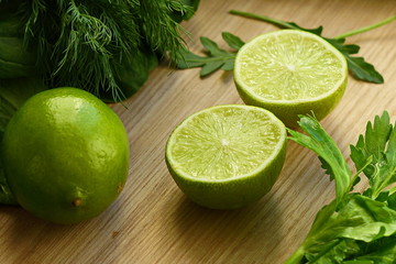 fresh lime and fresh herbs on a light wooden background