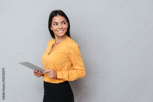 Fotomural Side view of business woman holding tablet computer