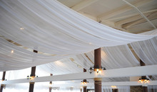 Fabric Drape On The Restaurant Ceiling. Bright Interior, Lighted Lantern. The Decor For The Wedding Party
