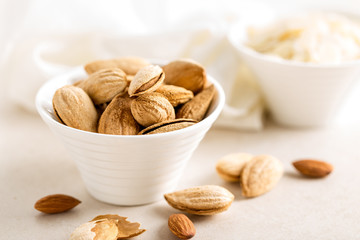 Almond nuts in a bowl on white background, healthy eating