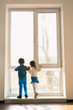 © Africa Studio - Cute little children near big window at home
