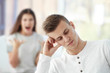 © Africa Studio - Young man at home with blurred angry girlfriend on background