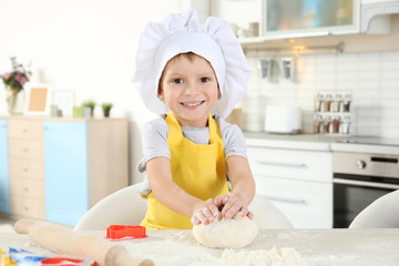 Wall Mural - Little boy making biscuits on table