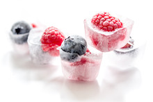 Ice Cubes With Frozen Berries On White Background