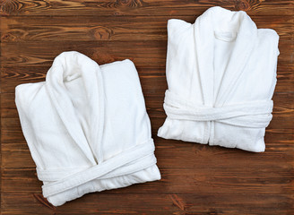 Wall Mural - Folded spa bathrobes on wooden background