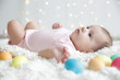© Africa Studio - Cute little baby with colorful Easter eggs lying on plaid at home