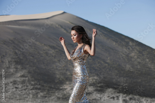 Fotografia, Obraz Beautiful fashion asian model in a luxury golden dress posing in a desert