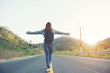 © patcharee11 - young women happy walking on the road at mounthain and sunet