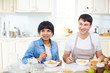 © pressmaster - Attractive mixed race woman and her Caucasian husband in apron having lunch together in lovely kitchen