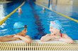 © pressmaster - Two children wearing caps and goggles laughing and having fun at PE lesson in clear water of swimming pool