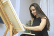 © Himchenko - creative woman paints a portrait on canvas