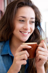 Wall Mural - beautiful young woman holding cup of coffee