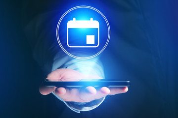 Poster - businessman hand holding mobile phone with calendar icon
