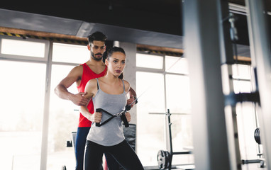 Wall Mural - Personal trainer assisting woman lose weight