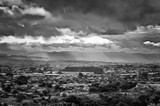 Fototapeta Na ścianę - View of suburbs in Auckland with mountains in the background and sunlight bursting through the clouds