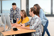 © W PRODUCTION - group of young cool hipster creative business people in casual wear working together in a meeting room of startup company looking at photography on computer