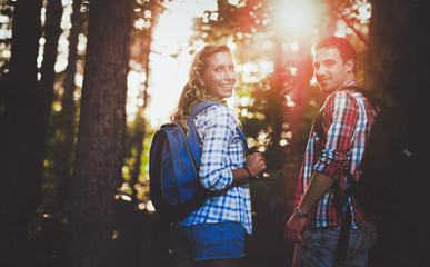 Wall Mural - Couple trekking and hiking in forest