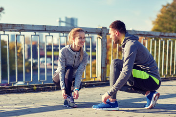 Poster - smiling couple tying shoelaces outdoors