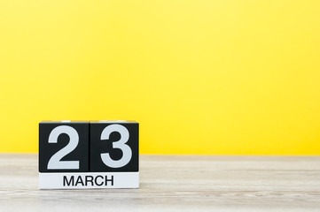 Wall Mural - March 23rd. Day 23 of month, calendar on table with yellow background. Spring time, empty space for text