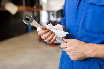 Canvas Print - auto mechanic or smith with wrench at car workshop