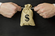 © vavstyle2 - bag of money on a black background, hands
