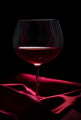 Wall Mural - Glass of wine on red silk