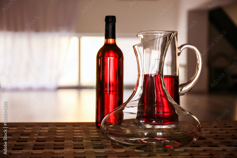 Glass carafe of wine on table against blurred background