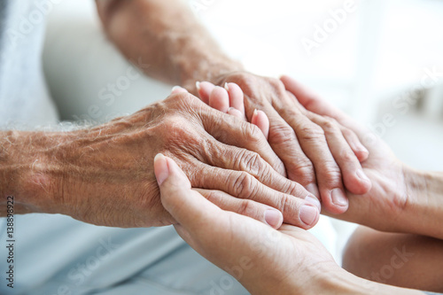 Fotografía Young woman holding senior man hands, closeup