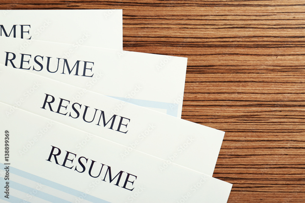 Resumes on wooden table, closeup