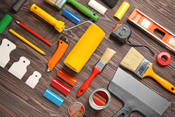 Flat lay composition of decorator and house renovation tools on wooden table