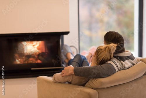 Cuadros en Lienzo Young couple in front of fireplace
