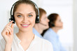 © rogerphoto - Call center operators. Focus at brunette business woman in headset