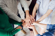 © SokRom - High angle shot of a group of colleagues standing in a circle with their hands in a huddle