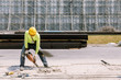 © Ekkasit A Siam - Construction worker  electric drill Drilling concrete ground in construction area