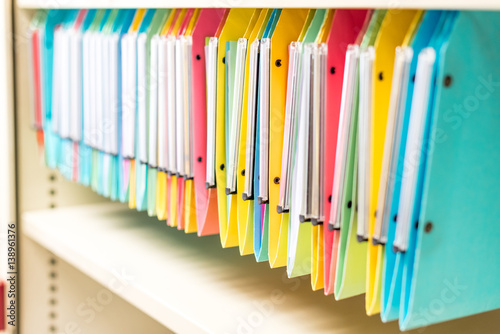 Fotografía set of multi colored folders / files in metal enclosure / closet