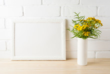 White Landscape Frame Mockup With Yellow Flowers Near Painted Brick Walls