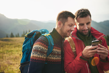 Wall Mural - Hikers using gps while out trekking in the wilderness