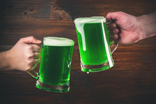 St Patrick's Day Concept Two Mug On Hands Green Beer Against Wooden Background