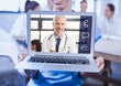 Woman holding a laptop with doctor on video call screen