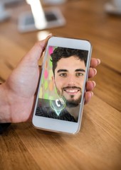 Poster - Hand holding mobile phone displaying man on video call screen