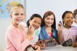 © WavebreakMediaMicro - Portrait of kids holding magnifying glass in classroom