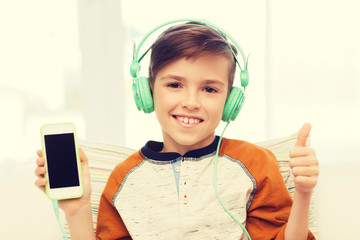 Wall Mural - happy boy with smartphone and headphones at home